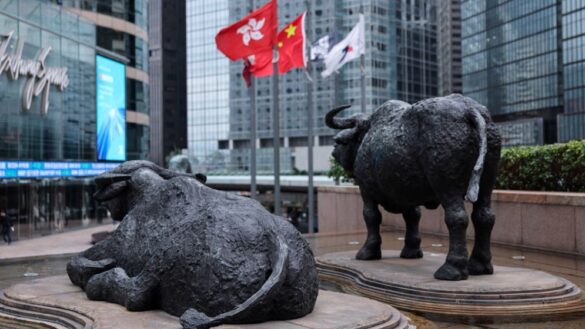 Bull statues near screens showing the Hang Seng stock index and stock prices outside Exchange Square, in Hong Kong, China, Feb 3, 2026. REUTERS/Tyrone Siu/File Photo